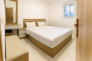 Ein Schlafzimmer mit einem Bett, Nachttischen, einem Spiegel, einem Fenster und einer Tür.