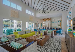 A spacious living area with a bright ceiling, large windows, and a view of an outdoor pool. - 8BR Near Disney Private Pool, spa & Lake View (Kissimmee)