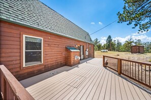 A wooden cabin with a deck, a garage, and a fenced yard. - Cute & Cozy & Remote peace seekers cabin, sleeps 4, 2 bed 2 bath, gorgeous views (Florissant)