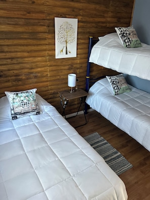 A room with two beds, a small table with a lamp, and a wall-mounted picture. - Comfortable, centrally located cabin in Puerto Natales (Puerto Natales)