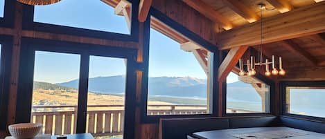 Un interior de madera con amplios ventanales que ofrecen vistas a la montaña.