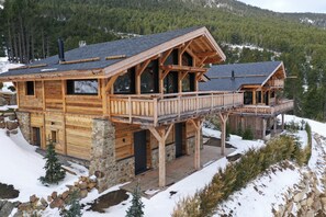 A wooden cabin with a balcony and a stone foundation, surrounded by snow and trees. - Chalet 4 Saisons, ski aux pieds (Les Angles)
