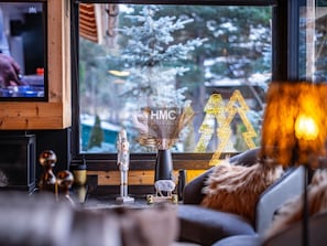 A cozy living area with a fireplace, a television, and a view of a snowy landscape through the window. - Bello, l'exception avec jacuzzi & vue Cerdagne (Bolquère)