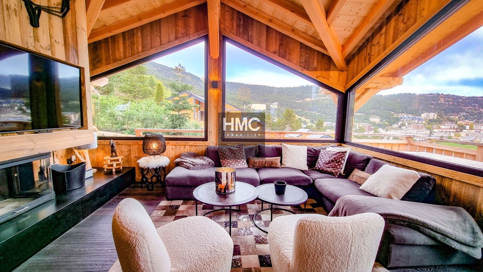 A cozy room with a large window, a fireplace, and a comfortable seating area with a sofa and chairs.