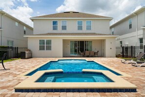 A two-story house with a swimming pool in the backyard. - 5BR Near Disney Pool, spa & Game Room (Kissimmee)