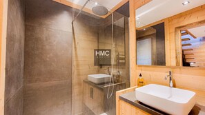 A modern bathroom with a glass-enclosed shower, a white sink, and a wooden vanity. - Sjodammen, Jacuzzi & vue époustouflante (Bolquère)