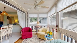 A sunroom with a ceiling fan, a dining area with a table and chairs, and a seating area with a sofa and armchairs. - Coastal Comfort in the Heart of Midtown Ocean City (Ocean City)