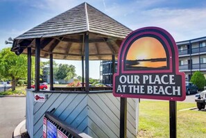 A gazebo with a sign that reads 'OUR PLACE AT THE BEACH' and a view of a building in the background. - Coastal Comfort in the Heart of Midtown Ocean City (Ocean City)