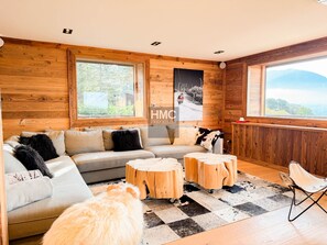 Ein gemütliches Zimmer mit einer Couch, einem flauschigen Hund und Blick ins Freie.