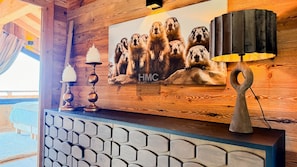 A wooden wall with a mounted picture of prairie dogs, a decorative lamp, and a geometric-patterned cabinet. - Chalet Sélène — Jacuzzi, cheminée & vue sur les mo (Bolquère)