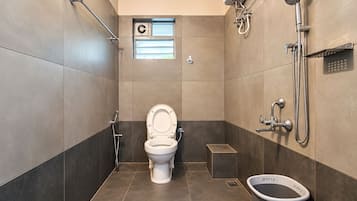 A modern bathroom with a toilet, bidet, and shower.