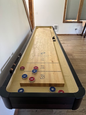 A shuffleboard table with numbered scoring areas and pucks. - House in Seeley Lake perfect for a relaxing getaway (Seeley Lake)