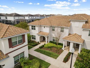A residential area with multiple two-story houses, each with a tiled roof and a small front yard. - 5BR Townhouse Near Disney Pool & Oasis Club (Davenport)