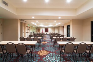 A conference room with multiple tables and chairs, a patterned carpet, and a flag on the wall. - Free Breakfast! 1 Bedroom Suite in Tallahassee (Tallahassee)