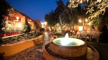 Un pati amb un bany d'hidromassatge, mobiliari exterior i un camí cap a un edifici.