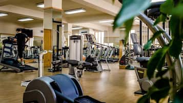 A gym with cardio machines, weight stations, and mirrors.