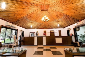A reception area with a checkered floor, a wooden ceiling, and a chandelier. - Saavaj Resort (Talala)