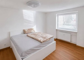 Et soveværelse med en seng, et vindue og en radiator.