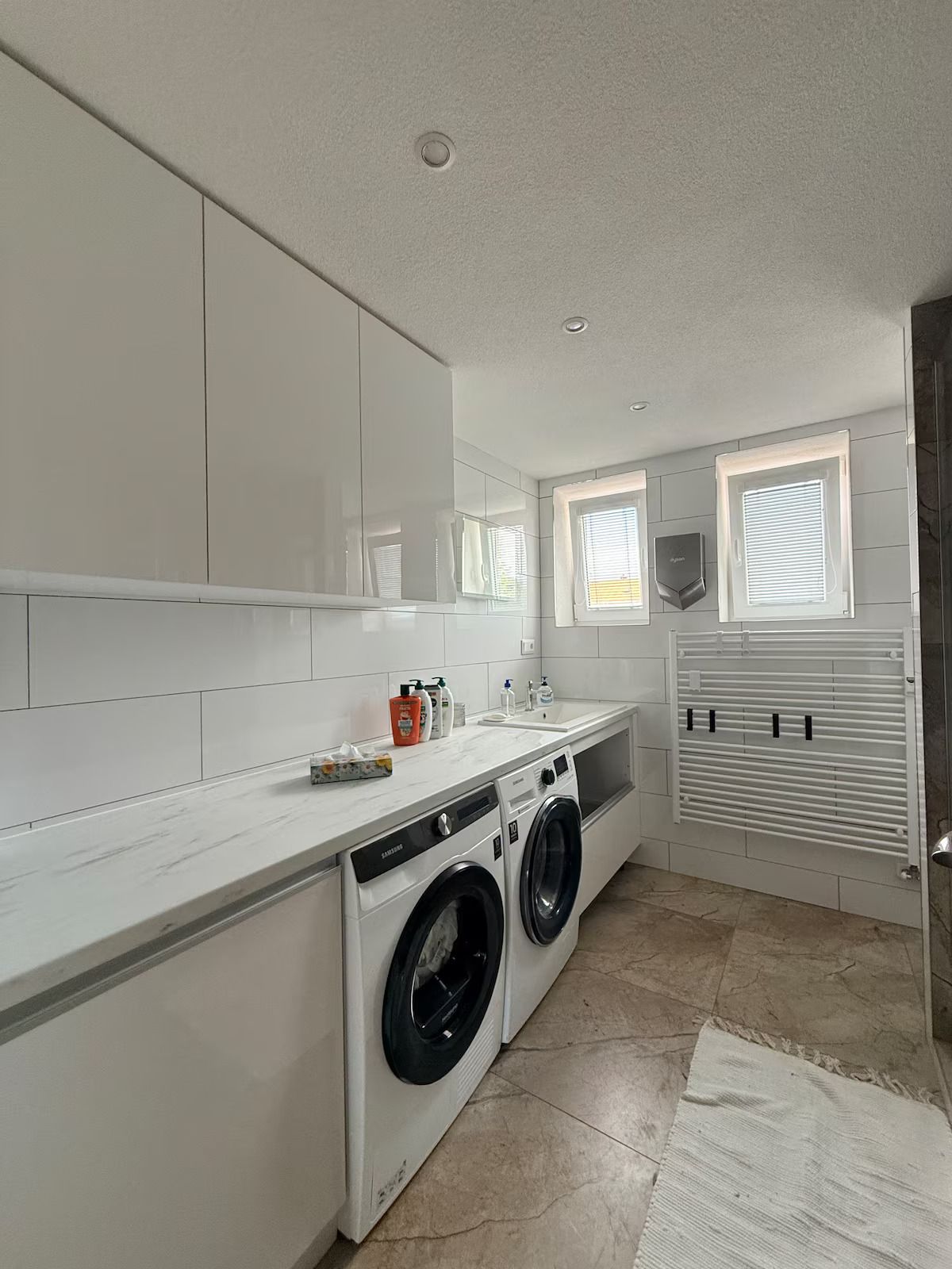 Un lavadero moderno con lavadora, secadora y lavabo.