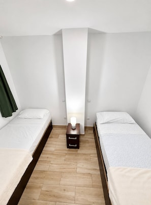 A small, modern room with two single beds, a nightstand with a lamp, and a wooden floor. - 403|Apartment with ocean views|Canteras Beach (Las Palmas de Gran Canaria)