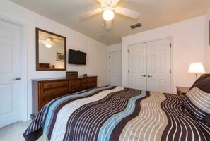 A bedroom with a bed, dresser, television, and ceiling fan. - 3BR Townhouse Near Disney Private Pool (Kissimmee)