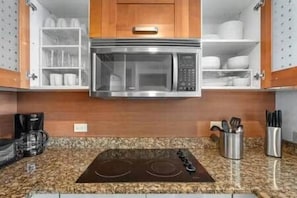 A kitchen with a built-in microwave, an induction cooktop, and a coffee maker. - Condado Lagoon-Apt in Condado near to the beach (San Juan)