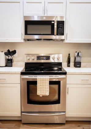 Una cocina equipada con electrodomésticos de acero inoxidable, incluyendo un microondas, horno y estufa.