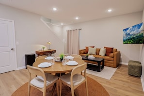 Una sala moderna con comedor, un sofá y un cuadro en la pared.