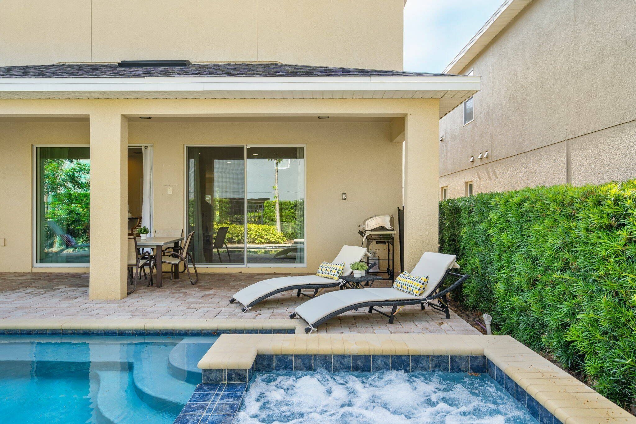 Un área de piscina con sillones reclinables y un jacuzzi.