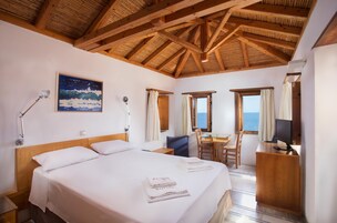 Habitación de hotel con cama, escritorio, silla, televisión y un cuadro en la pared.