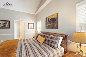 A bedroom with a bed, a nightstand, a lamp, and a painting on the wall. - Large Sugar Mountain Home with Fireplace and Covered Deck (Sugar Mountain)