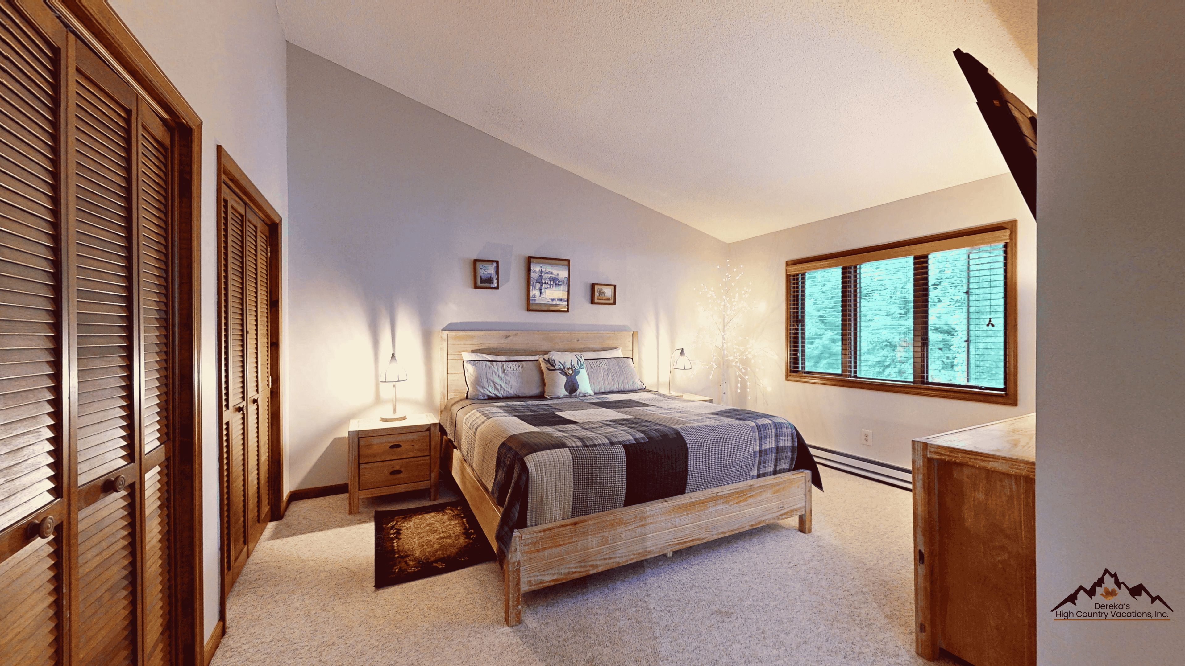 A bedroom with a bed, bedside tables, a window, and a wardrobe.