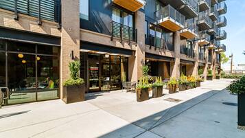 A modern building with outdoor seating and planters.