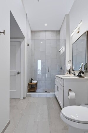 Un baño moderno con ducha, inodoro y lavamanos.
