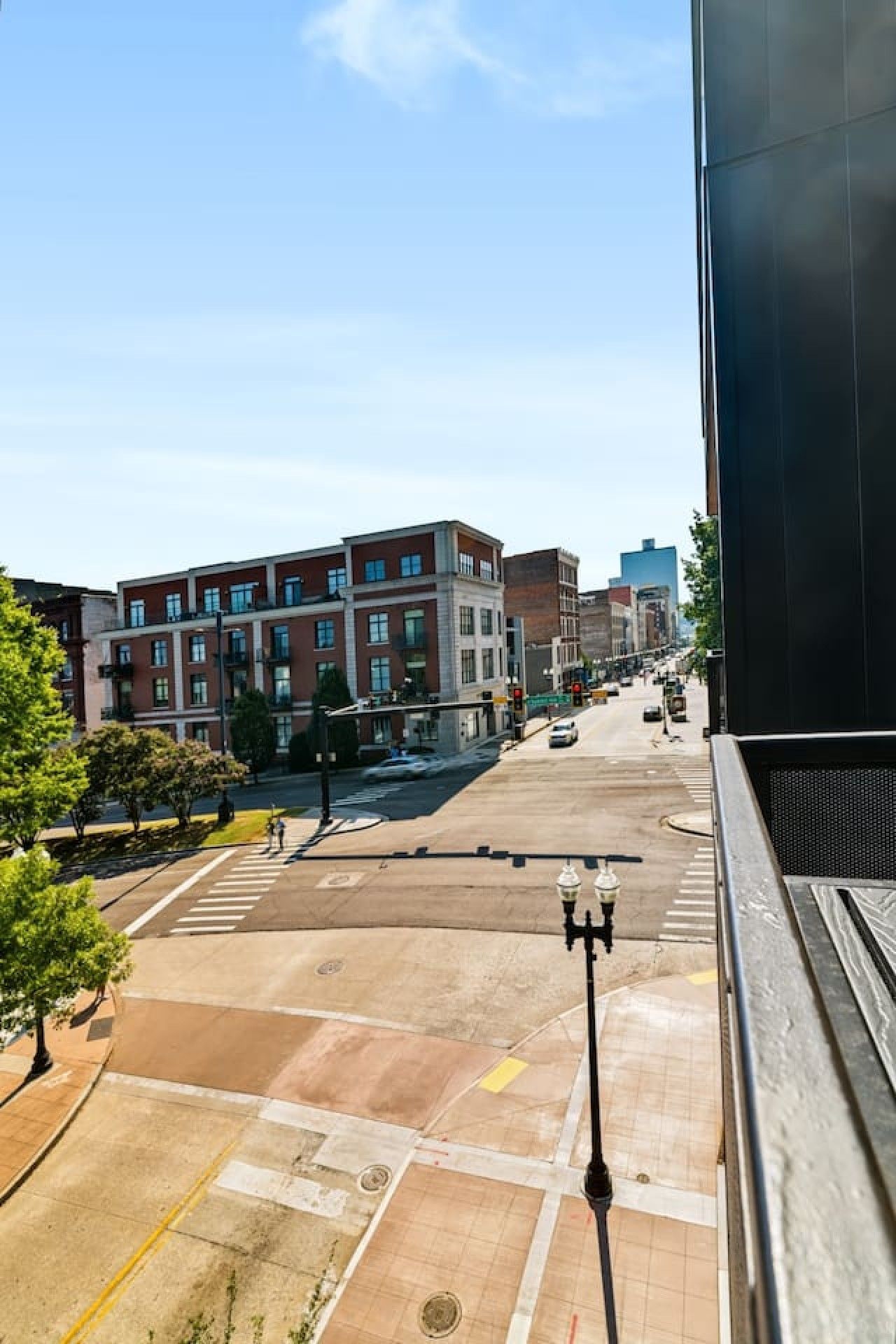 Une vue de rue avec des bâtiments, des passages piétons et un ciel dégagé.