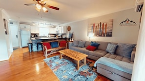 A modern living room with a grey sofa, wooden coffee table, and a colorful rug. - Powdered Sugar at Shallowford Walk (Sugar Mountain)