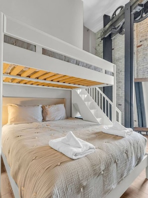 Un letto a castello con una scala in legno, ringhiere bianche e una scala.