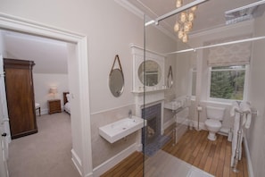 A bathroom with a glass shower enclosure, a white sink, a toilet, and a mirror. - Lys-na-greyne (Aboyne)