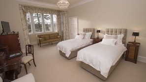 A bedroom with two beds, a sofa, a desk, and a chandelier. - Lys-na-greyne (Aboyne)