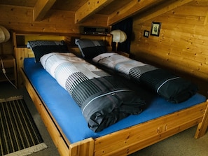 A wooden bunk bed with blue bedding and a radio. - Clarossa Appartement/Fewo, Dusche oder Bad, WC 6-Bettwohnung by Interhome (Bellwald)