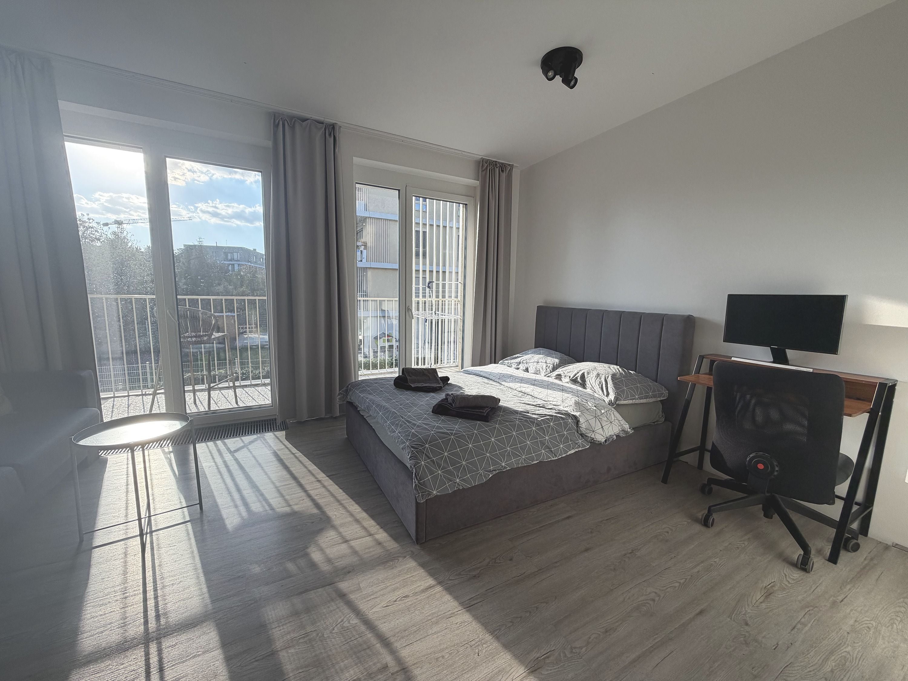 Un dormitorio con cama, escritorio, silla y televisor.
