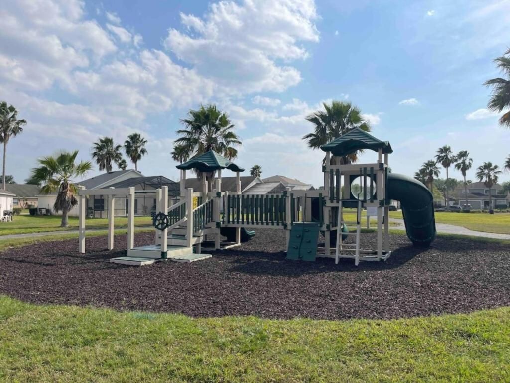 A playground with a slide, climbing structures, and a covered area.