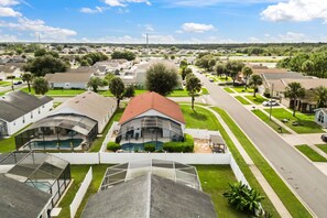 Un quartier résidentiel avec des maisons, une piscine et une route.