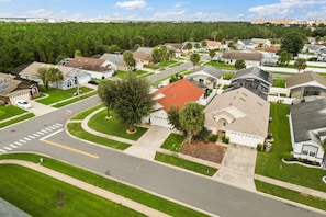 A residential area with houses, roads, and greenery. - Near Disney + Private Pool 4 BD/ 3BA Indian Creek - 2625 SC (Kissimmee)