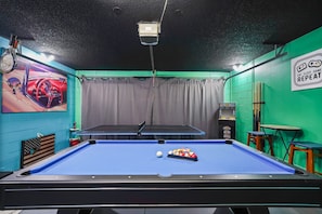 A pool table with a cue ball and billiard balls, a table tennis table, a wall with a poster, and a sign that says 'EAT SLEEP GAME REPEAT'. - Near Disney + Private Pool 4 BD/ 3BA Indian Creek - 2625 SC (Kissimmee)
