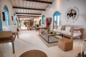 A spacious living room with a sofa, coffee table, and a decorative wall piece. - Casa La Torre (Porto Seguro)