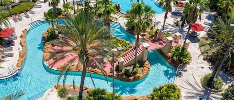 A resort with multiple swimming pools, palm trees, and sun loungers.
