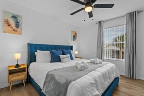 A bedroom with a bed, nightstands, a ceiling fan, and a window with curtains. - 3BR Near Disney Mickey & Harry Potter Rooms (Kissimmee)