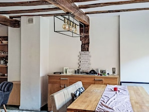 A dining area with a wooden table, chairs, and a bookshelf. - Alte Scheune Loft by Interhome (Idstein)