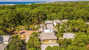 A residential area with multiple houses surrounded by dense greenery and a clear view of the ocean. - 🛺 Sun of a Beach - 5BR + Golf Cart + Bikes + Rooftop Hangout (Santa Rosa Beach)